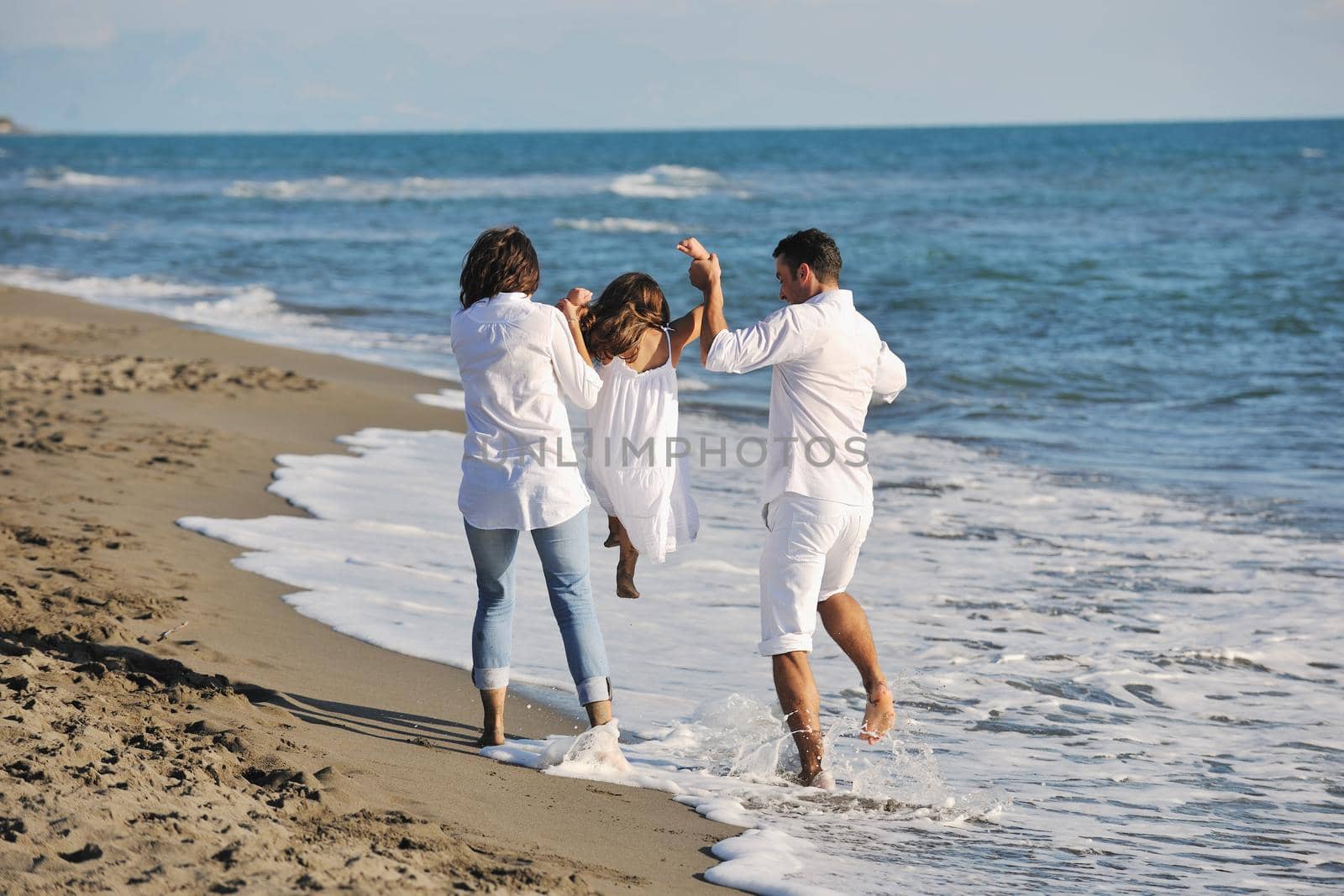 happy young  family have fun on beach by dotshock