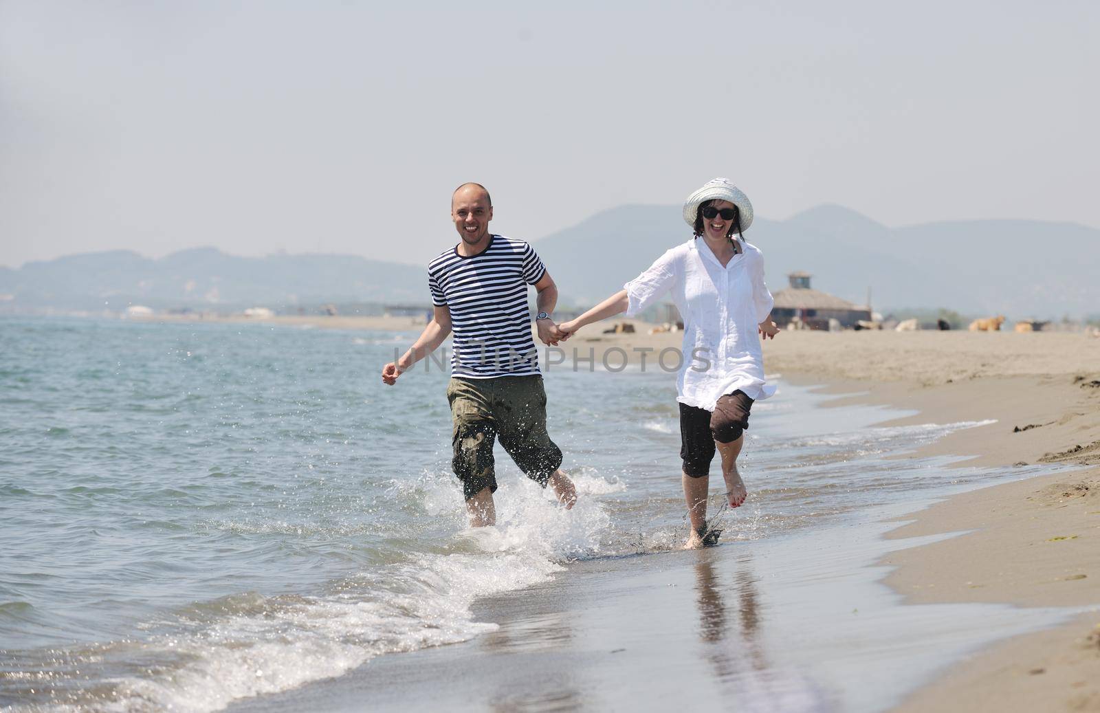 happy young couple have fun and romantic moments on beach at summer season and representing happynes and travel concept