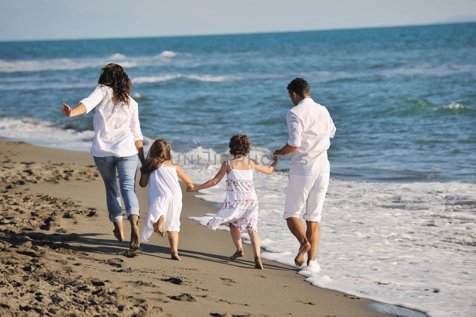 happy young family in white clothing have fun at vacations on beautiful beach 