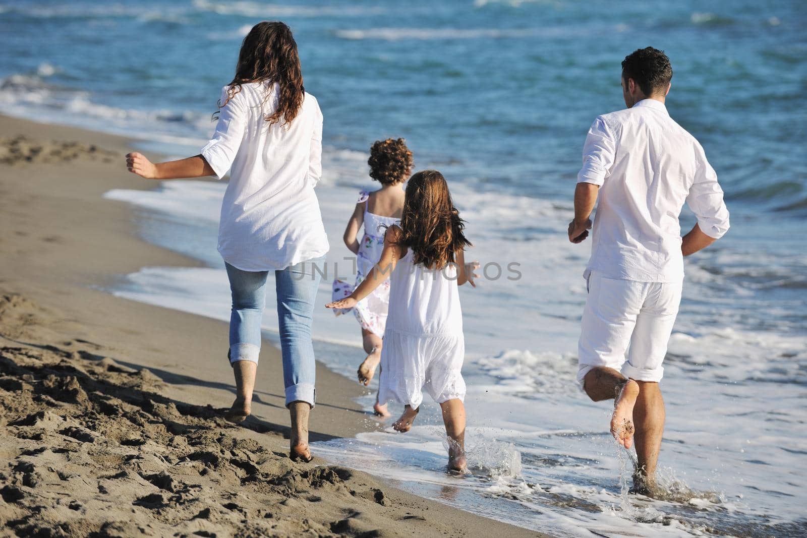 happy young  family have fun on beach by dotshock