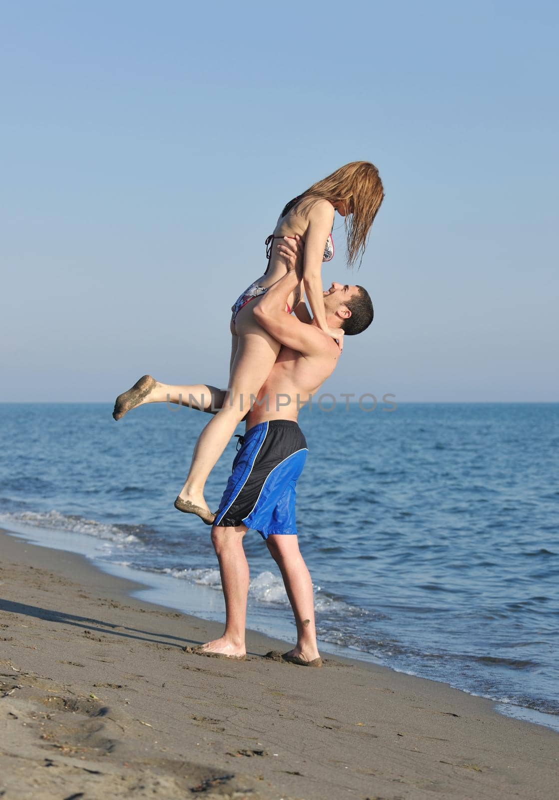 happy young couple have romantic time on beach at sunset