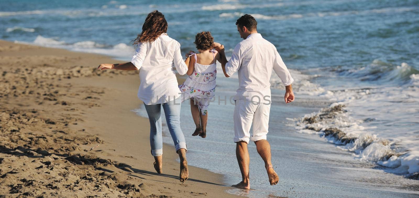 happy young family in white clothing have fun at vacations on beautiful beach 