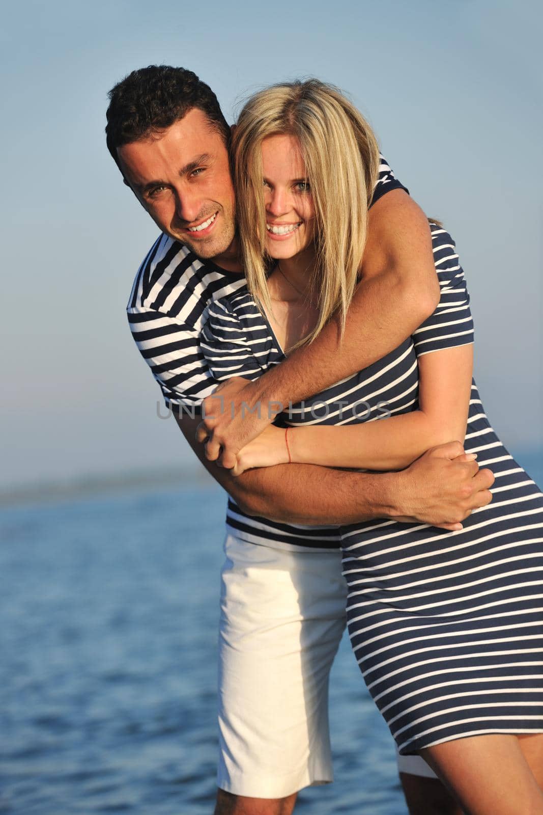 happy young couple have romantic time on beach at sunset