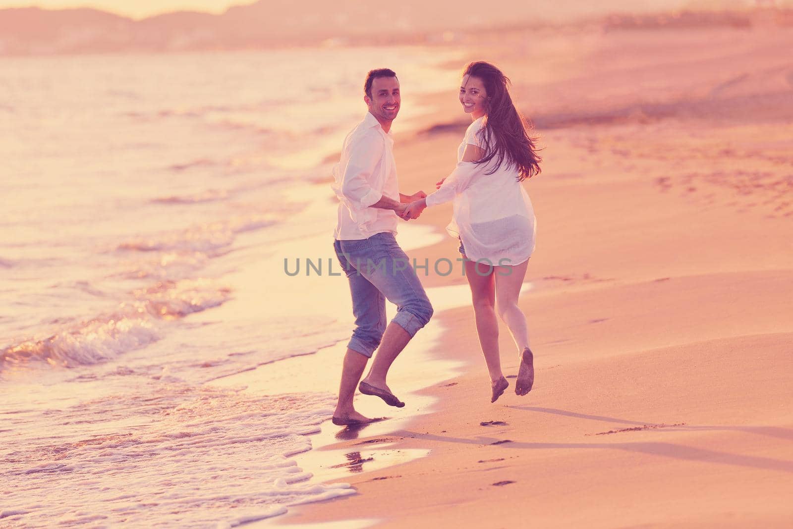 happy young romantic couple in love have fun on beautiful beach at beautiful summer day