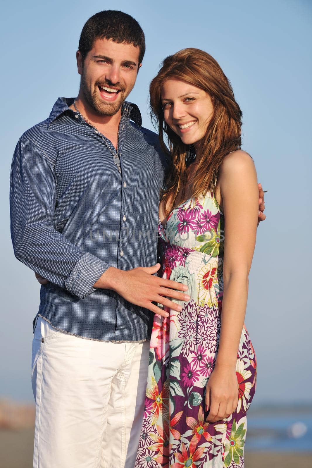 happy young couple have romantic time on beach at sunset