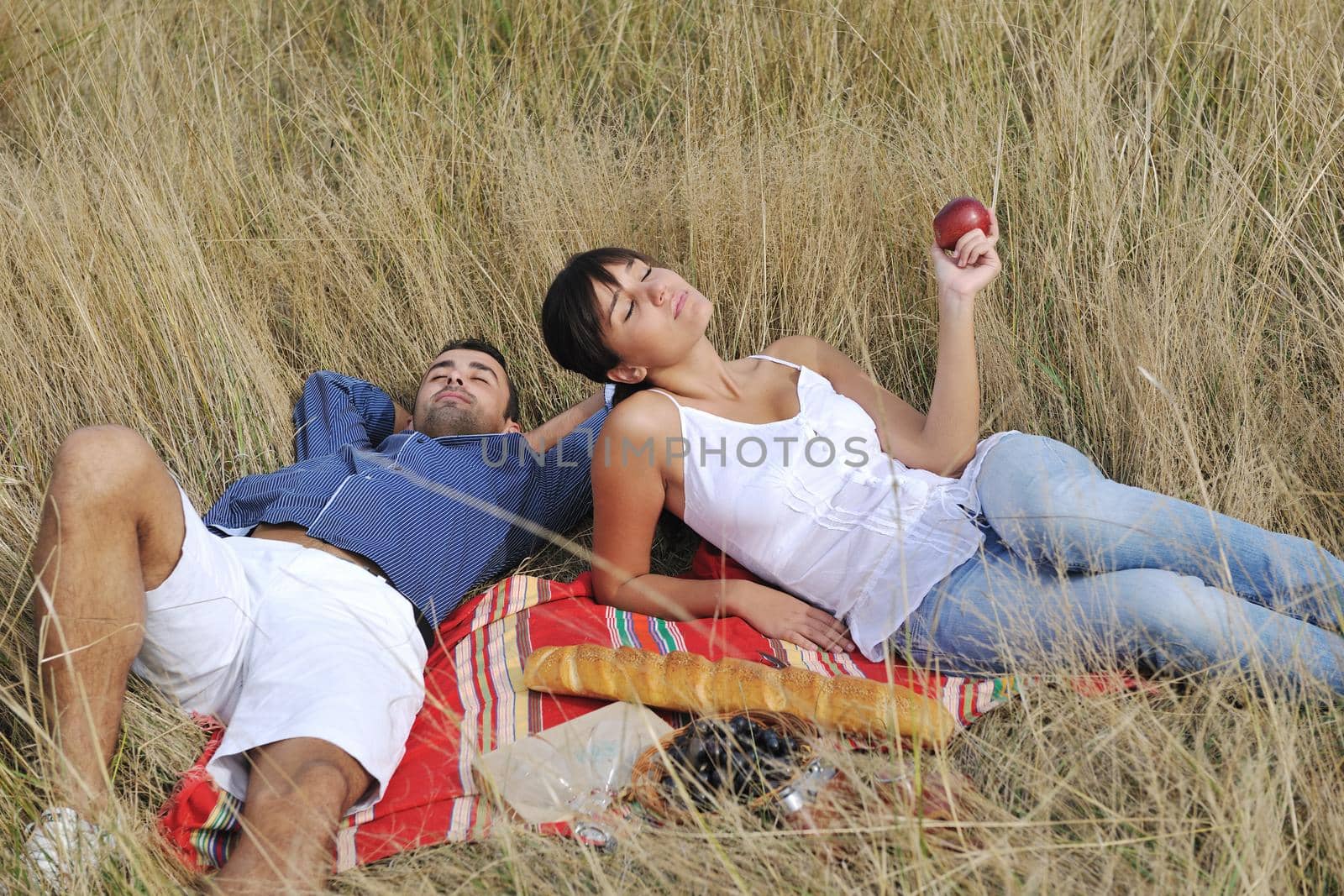 happy young couple enjoying  picnic on the countryside in the field  and have good time