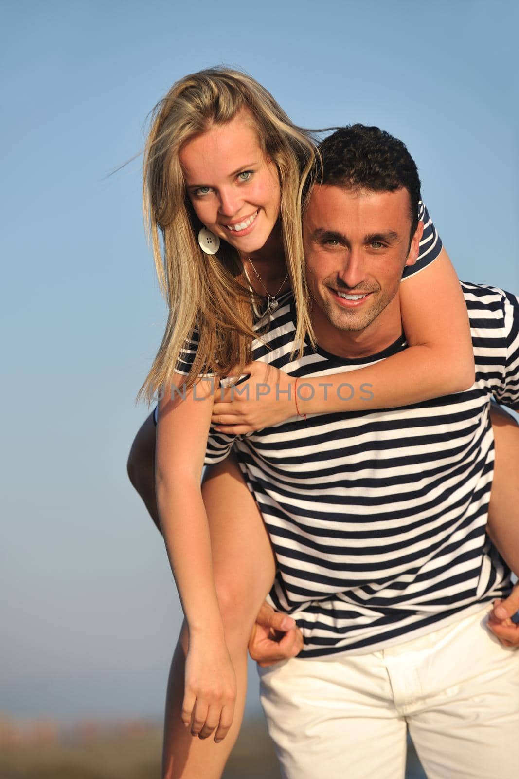 happy young couple have romantic time on beach at sunset