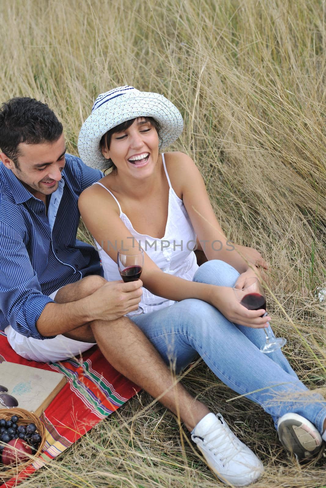 happy young couple enjoying  picnic on the countryside in the field  and have good time