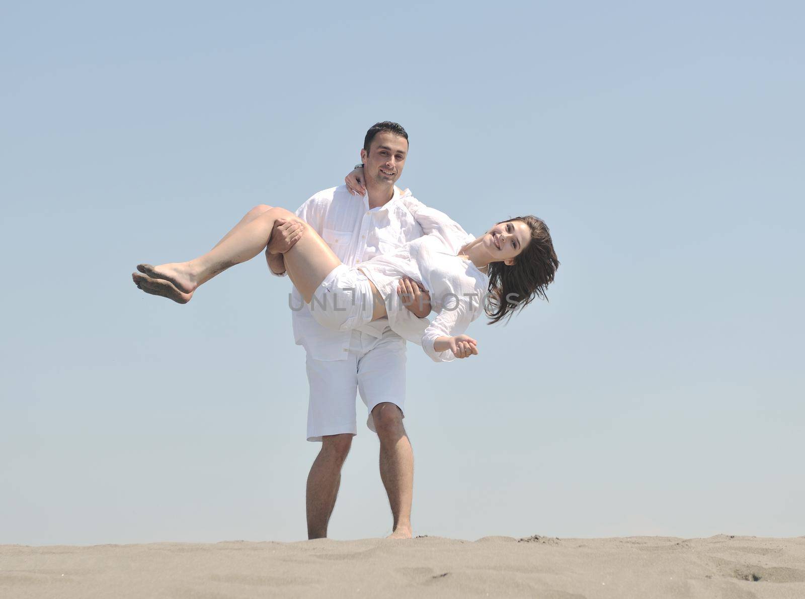 happy young couple have fun and romantic moments on beach at summer season and representing happynes and travel concept