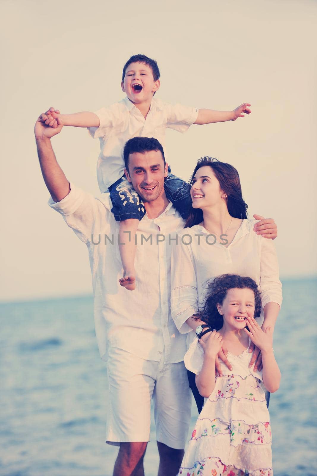 happy young family have fun and live healthy lifestyle on beach