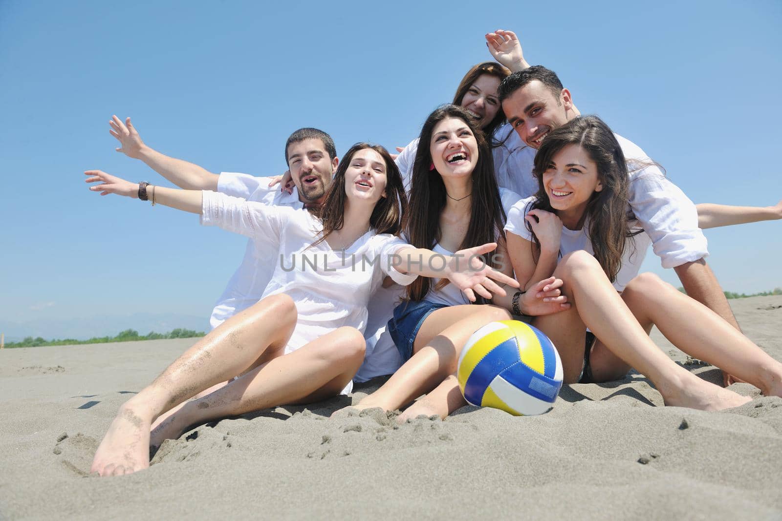 happy young  people group have fun on beach by dotshock