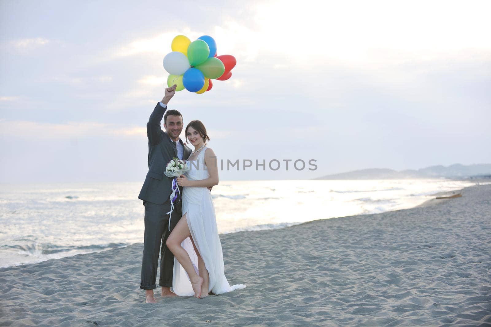 happy just married young couple celebrating and have fun at beautiful beach sunset