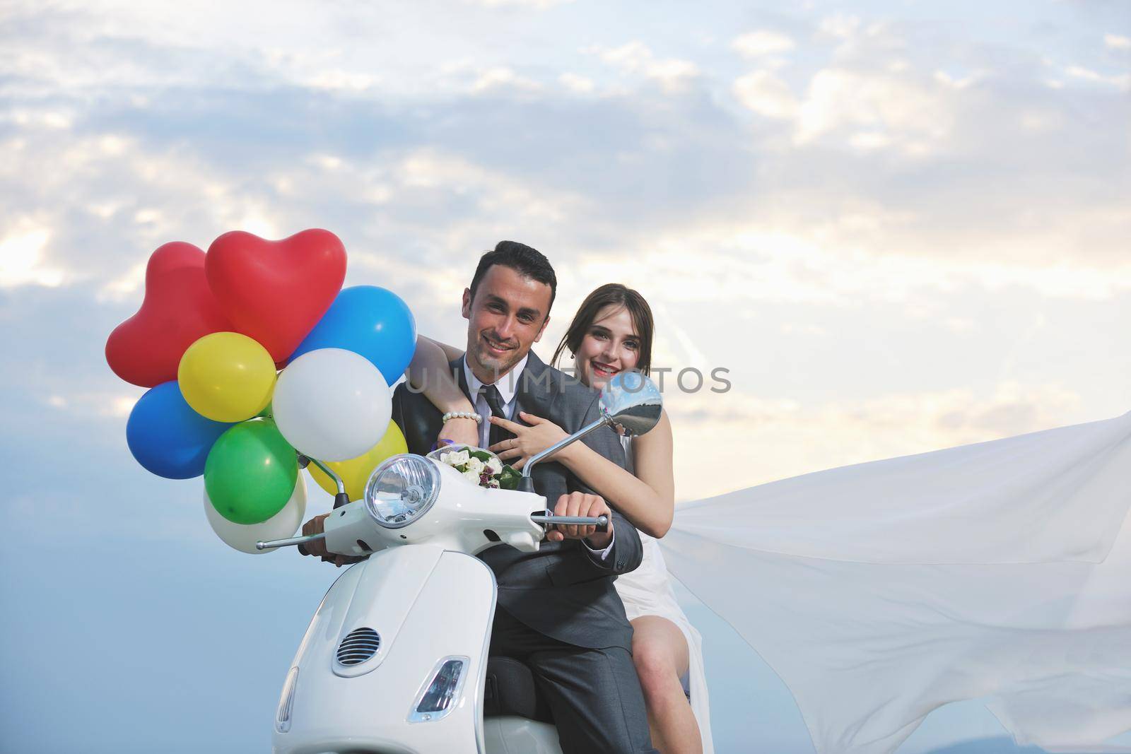 just married couple on the beach ride white scooter by dotshock