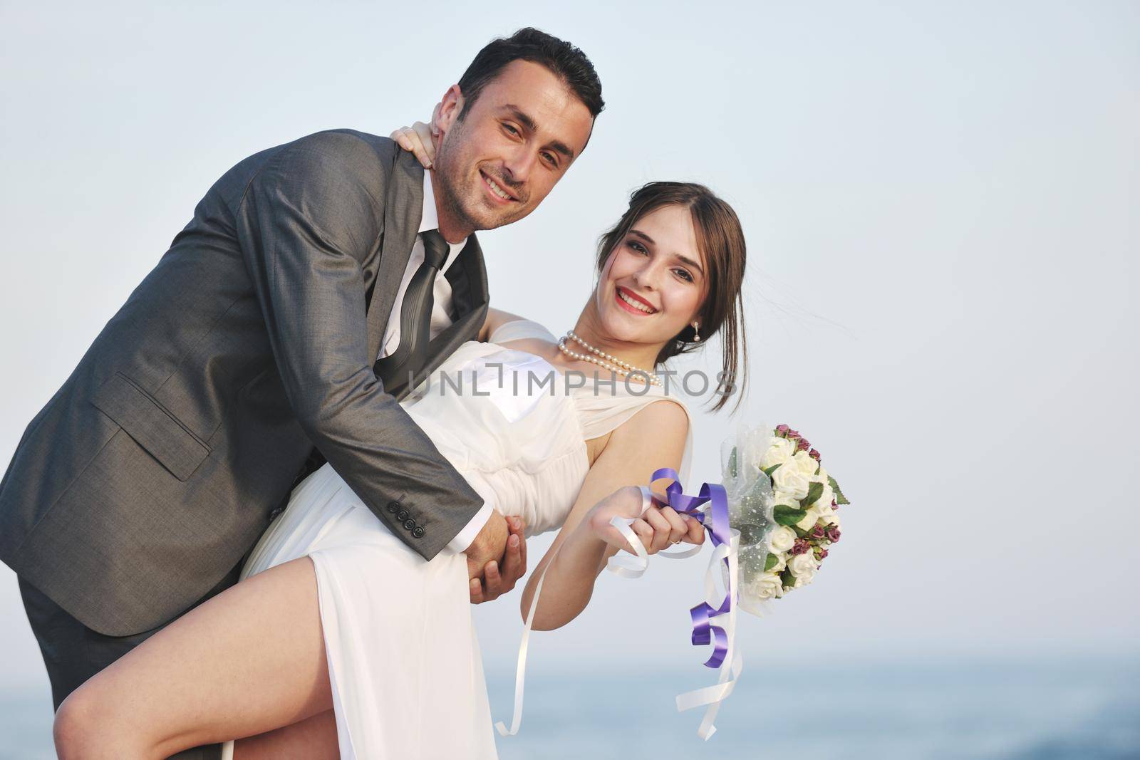 happy just married young couple celebrating and have fun at beautiful beach sunset