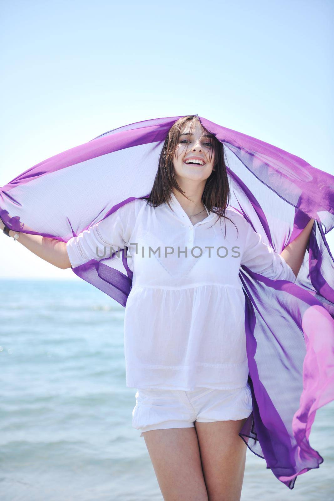 happy young woman relax on beautiful  beach at fresh summer morning and enjoy first ray of sun