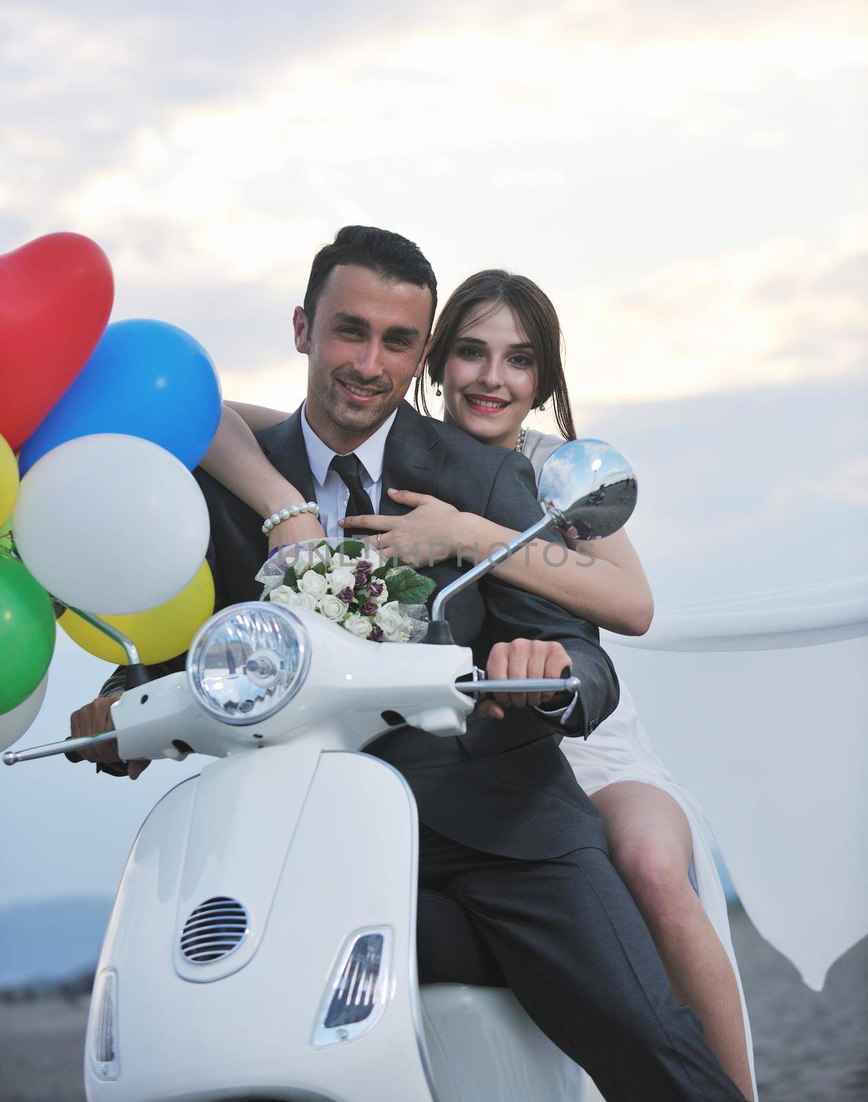 just married couple on the beach ride white scooter by dotshock