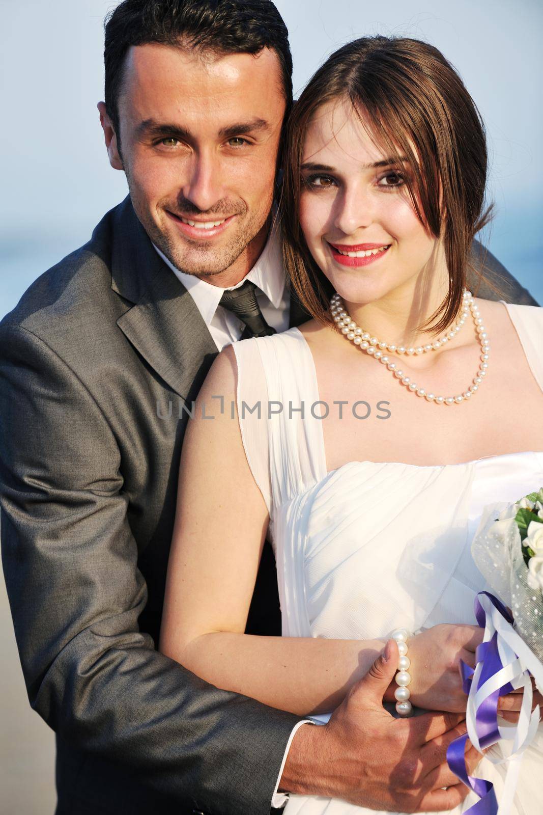 happy just married young couple celebrating and have fun at beautiful beach sunset