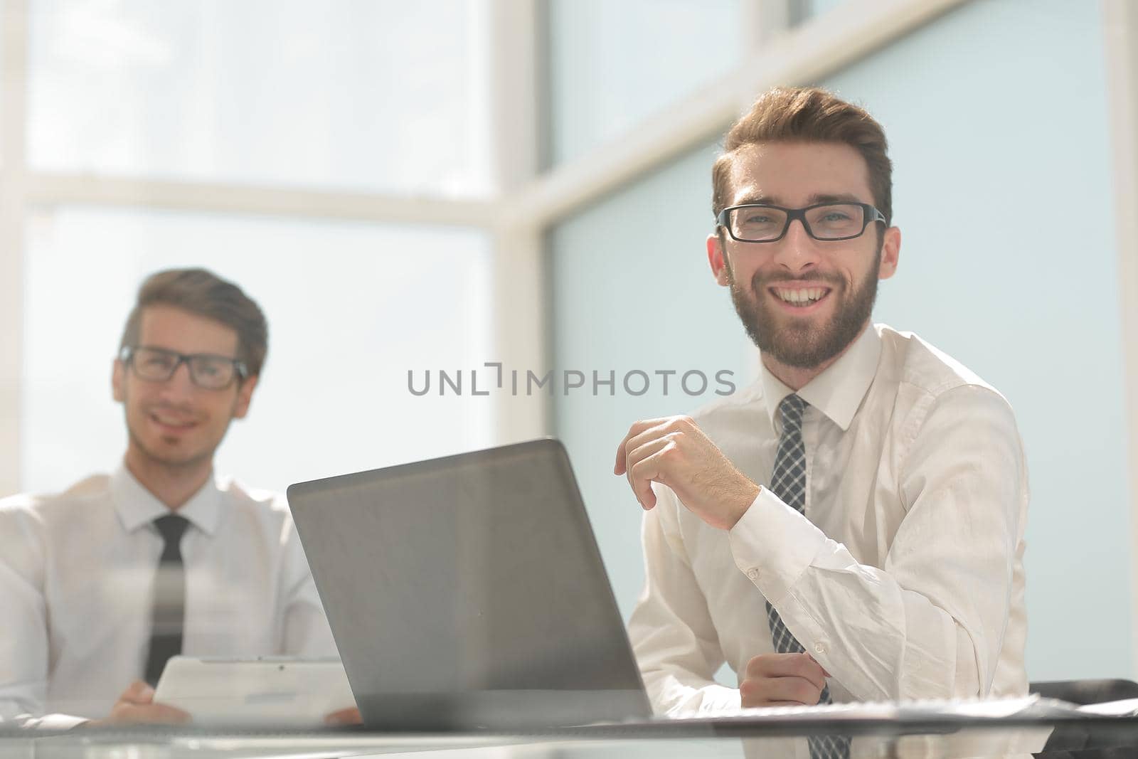 close up.smiling business colleagues sitting at the Desk.photo with space for text