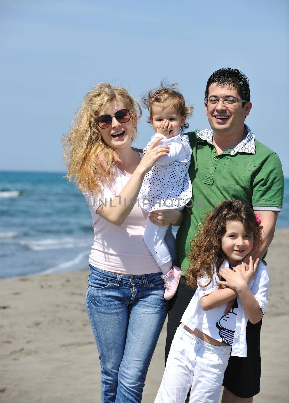 happy young family have fun and live healthy lifestyle on beach