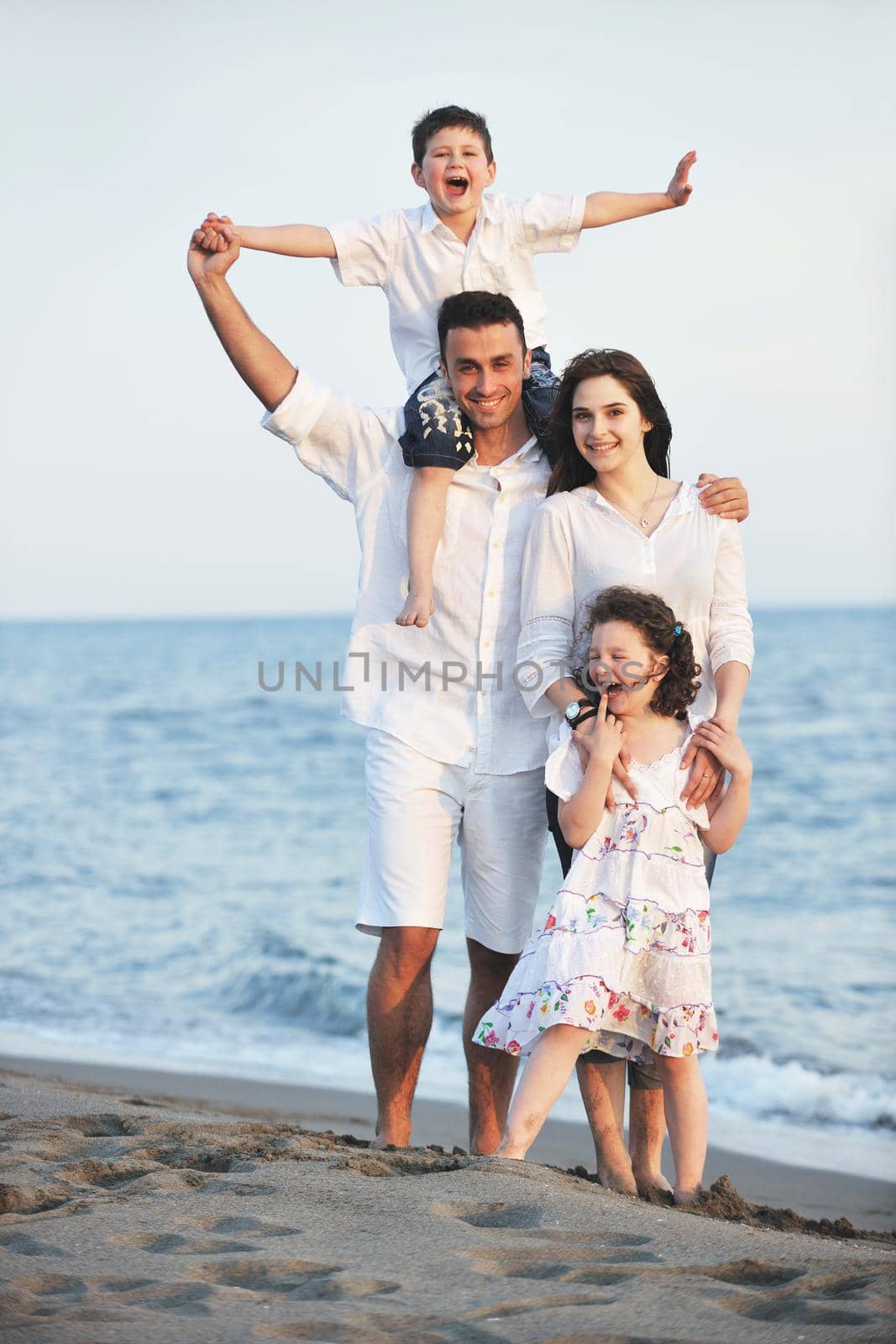 happy young family have fun and live healthy lifestyle on beach