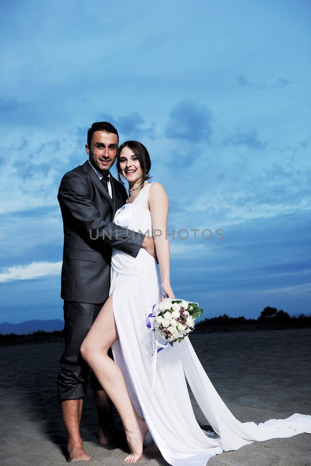 happy just married young couple celebrating and have fun at beautiful beach sunset