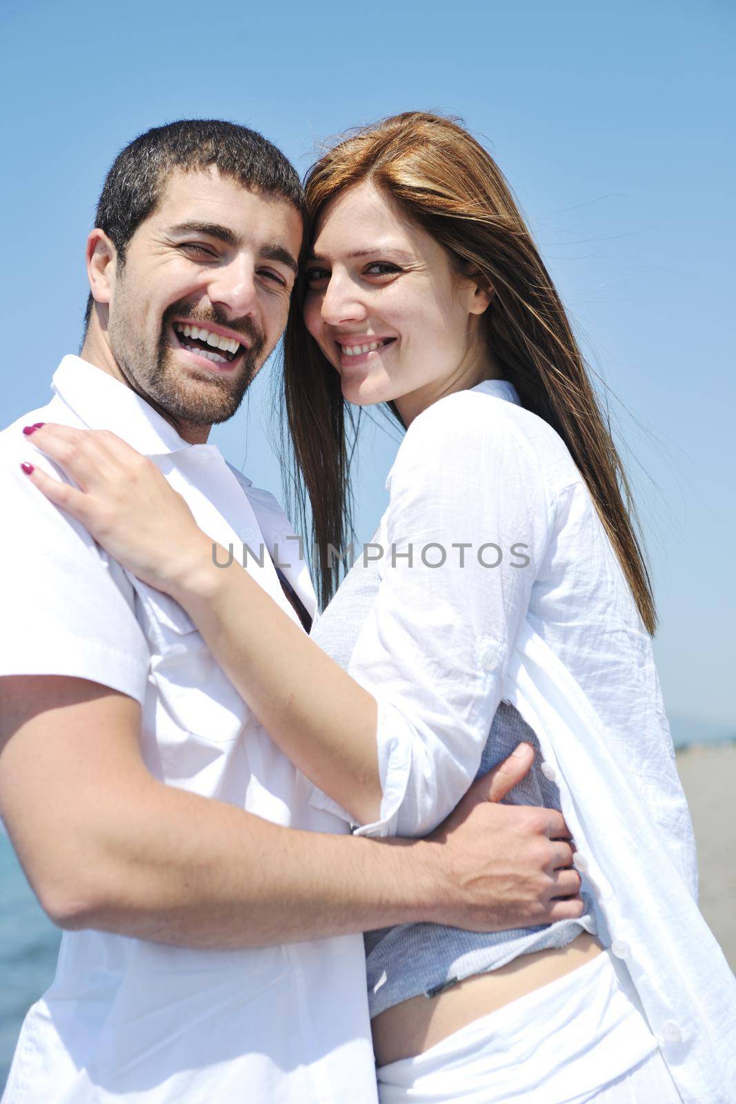 happy young couple have fun on beach by dotshock