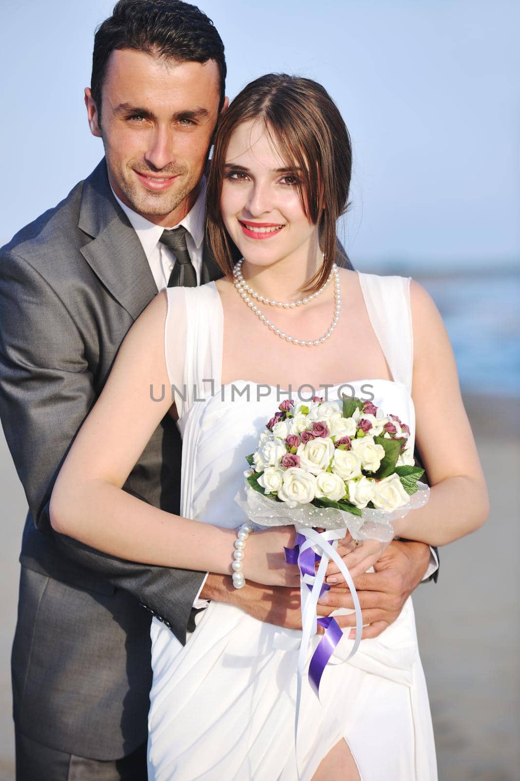 happy just married young couple celebrating and have fun at beautiful beach sunset