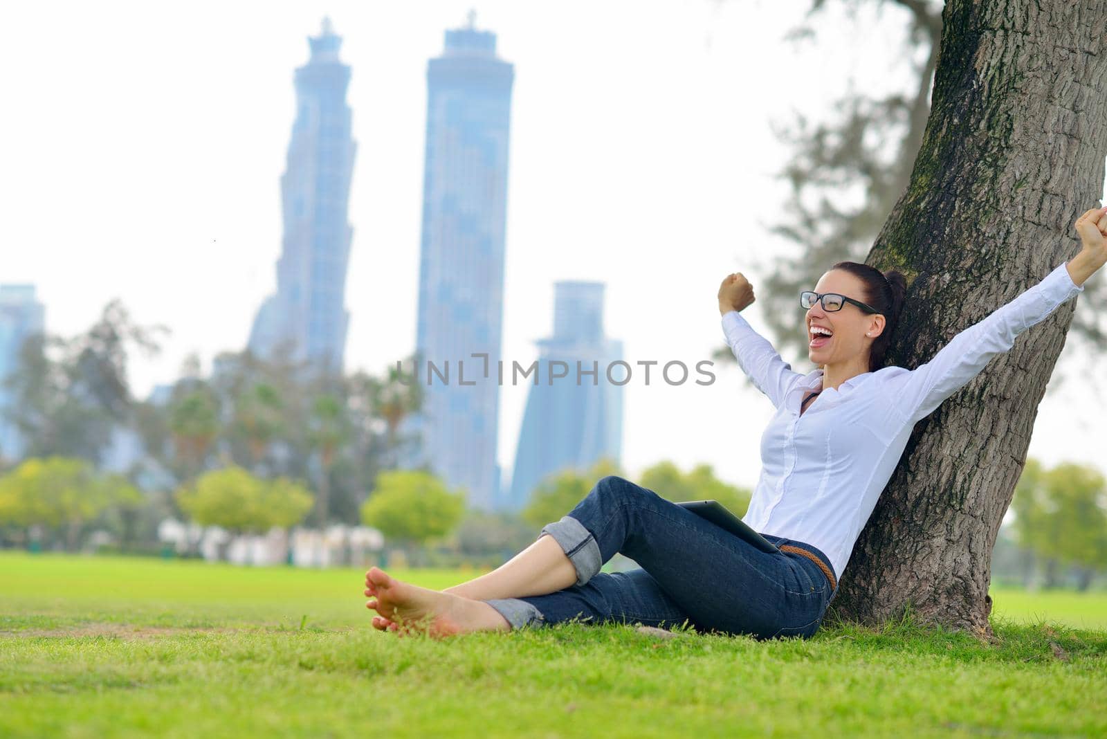 Beautiful young woman with  tablet in park by dotshock