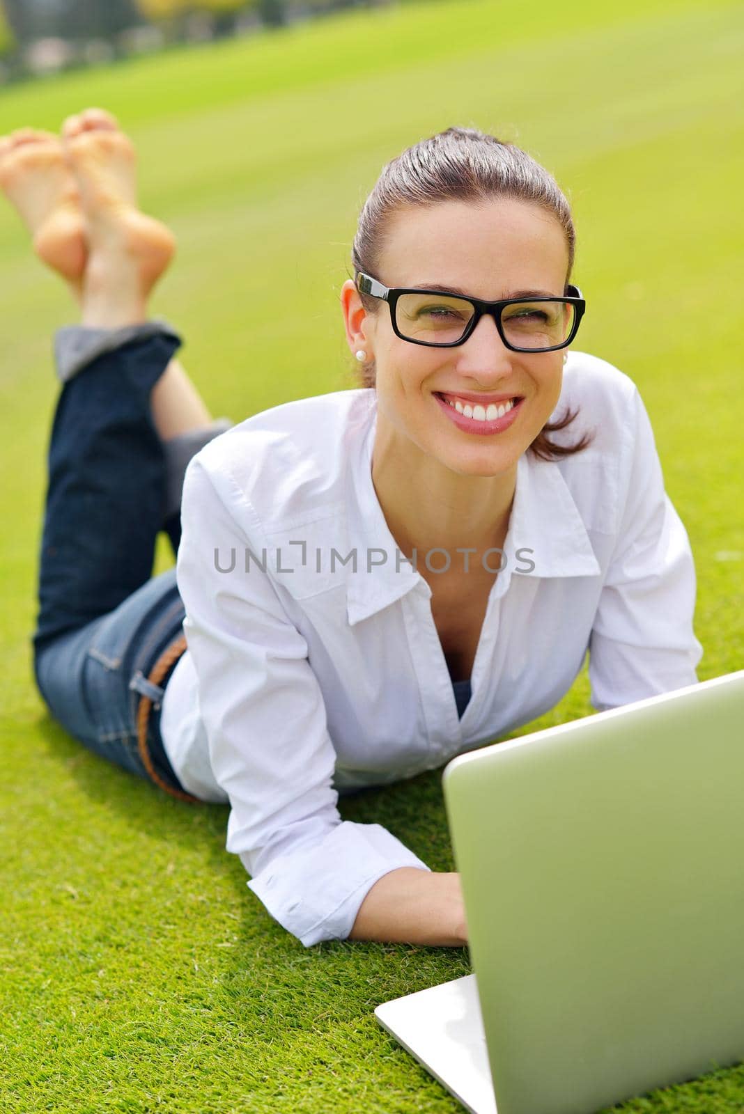 happy young student woman with laptop in city park study