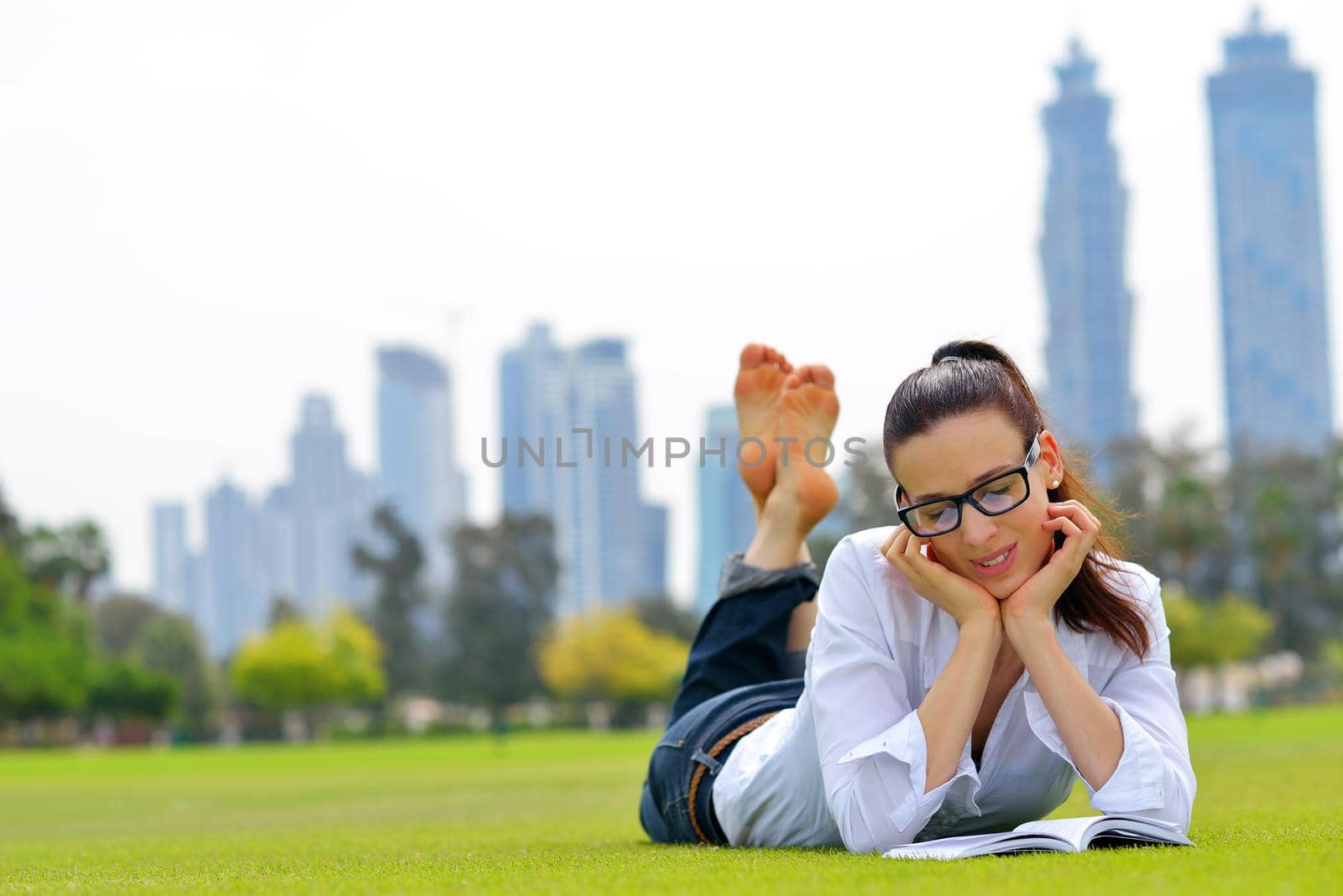 Young student woman reading a book and study in the park