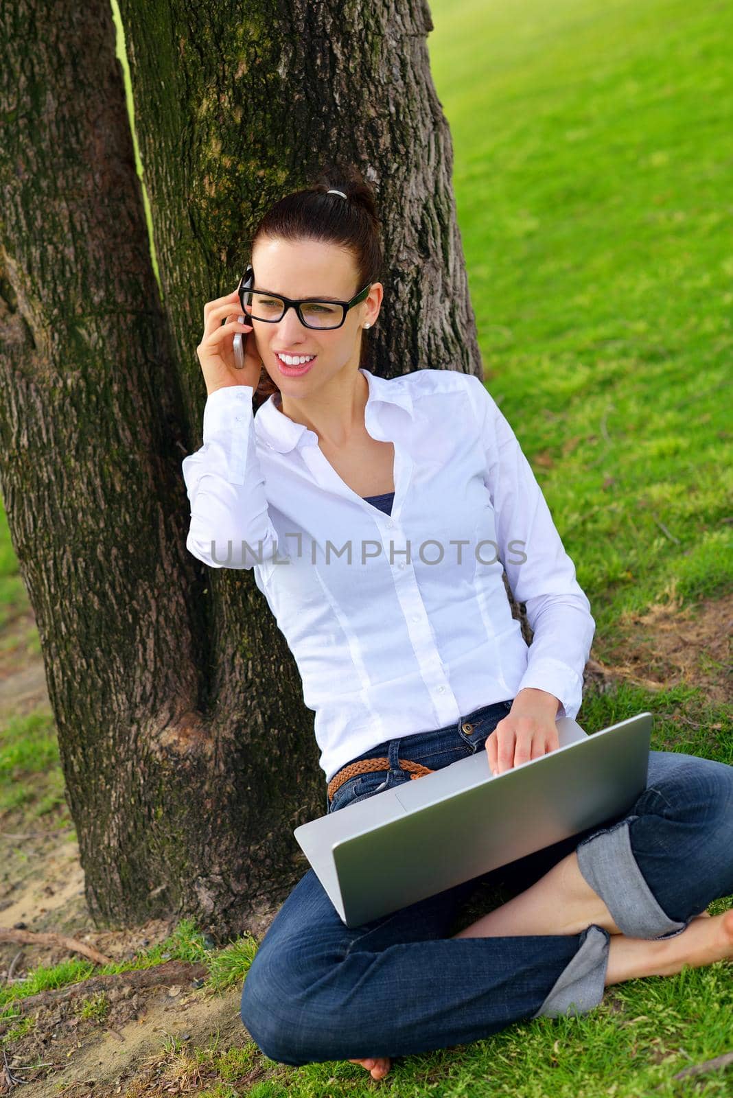 happy young student woman with laptop in city park study