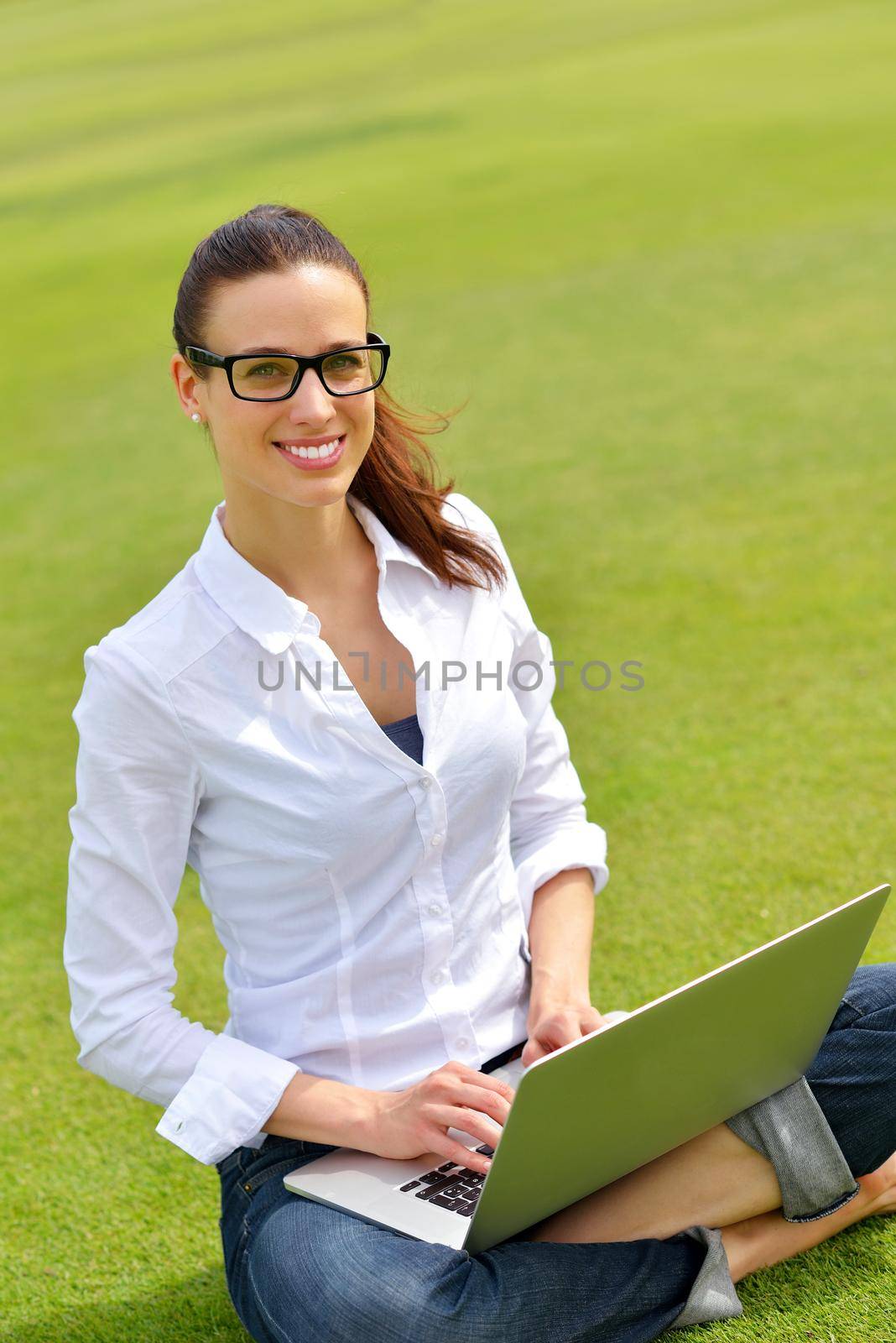 happy young student woman with laptop in city park study