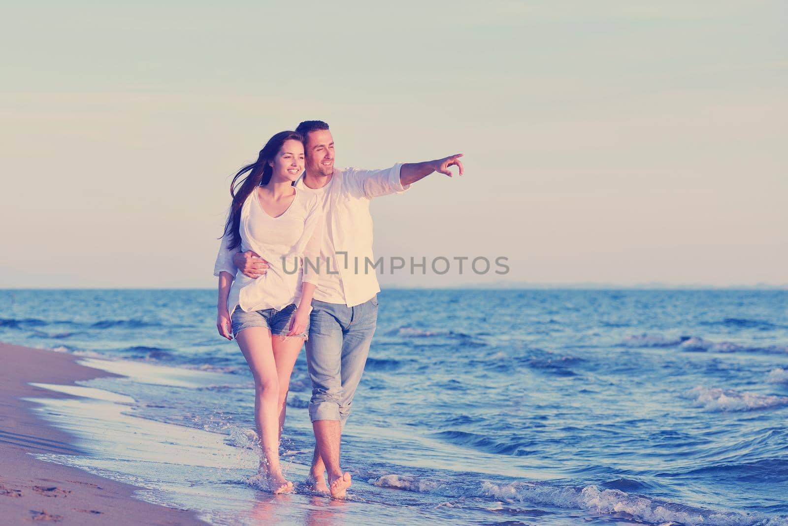 happy young romantic couple in love have fun on beautiful beach at beautiful summer day