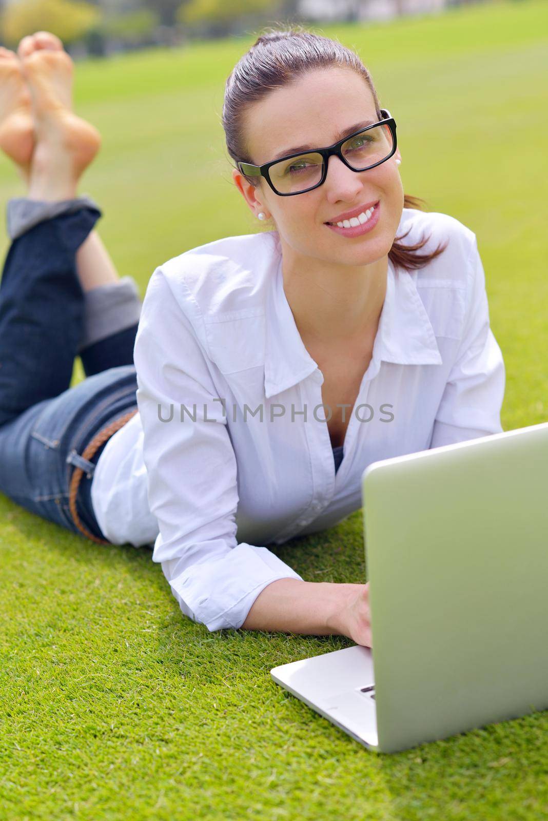 happy young student woman with laptop in city park study