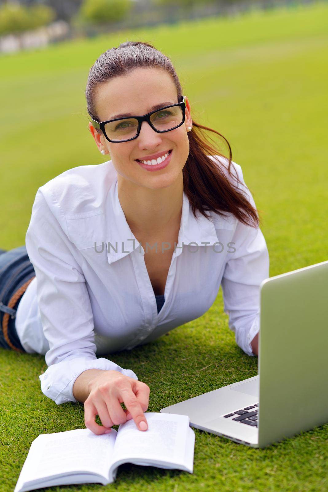 happy young student woman with laptop in city park study