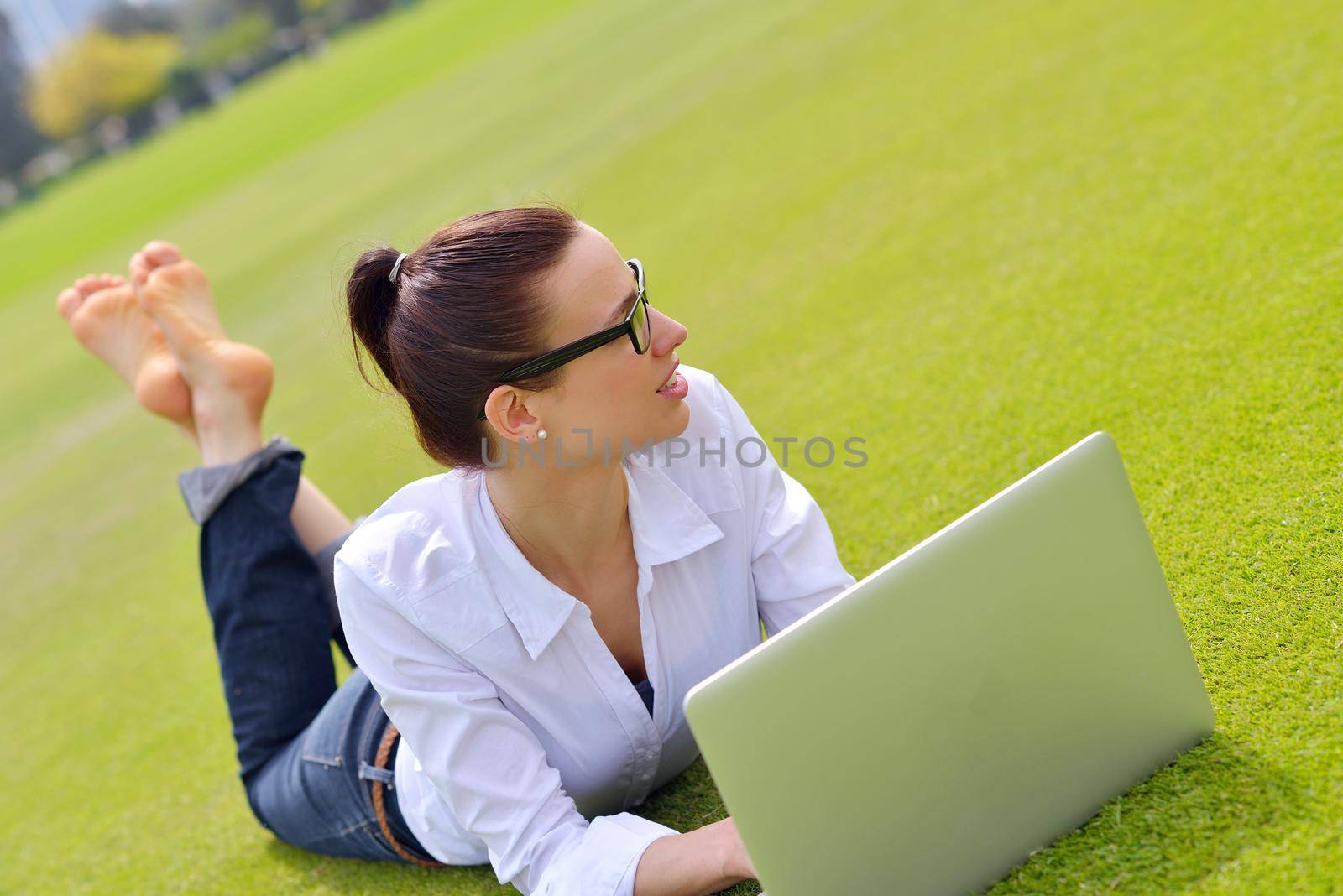 happy young student woman with laptop in city park study