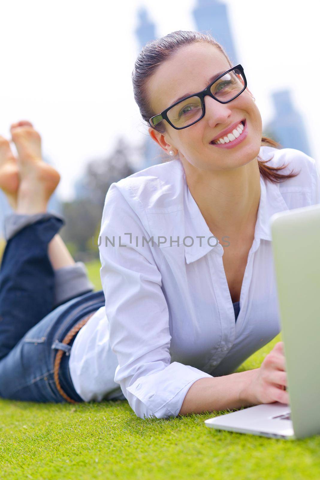 happy young student woman with laptop in city park study