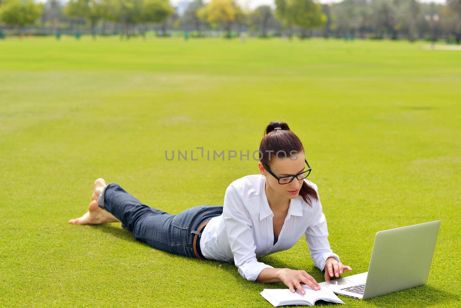 happy young student woman with laptop in city park study