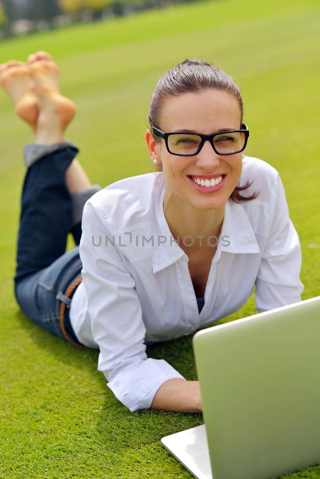 happy young student woman with laptop in city park study