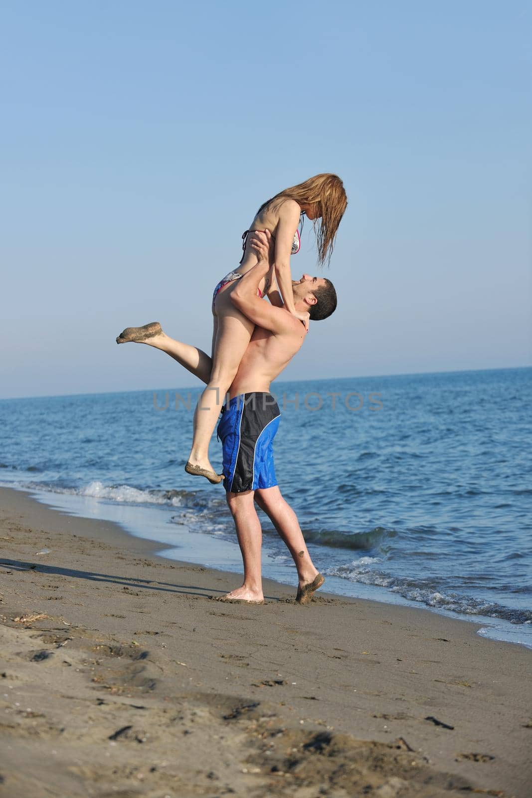 happy young couple have romantic time on beach by dotshock