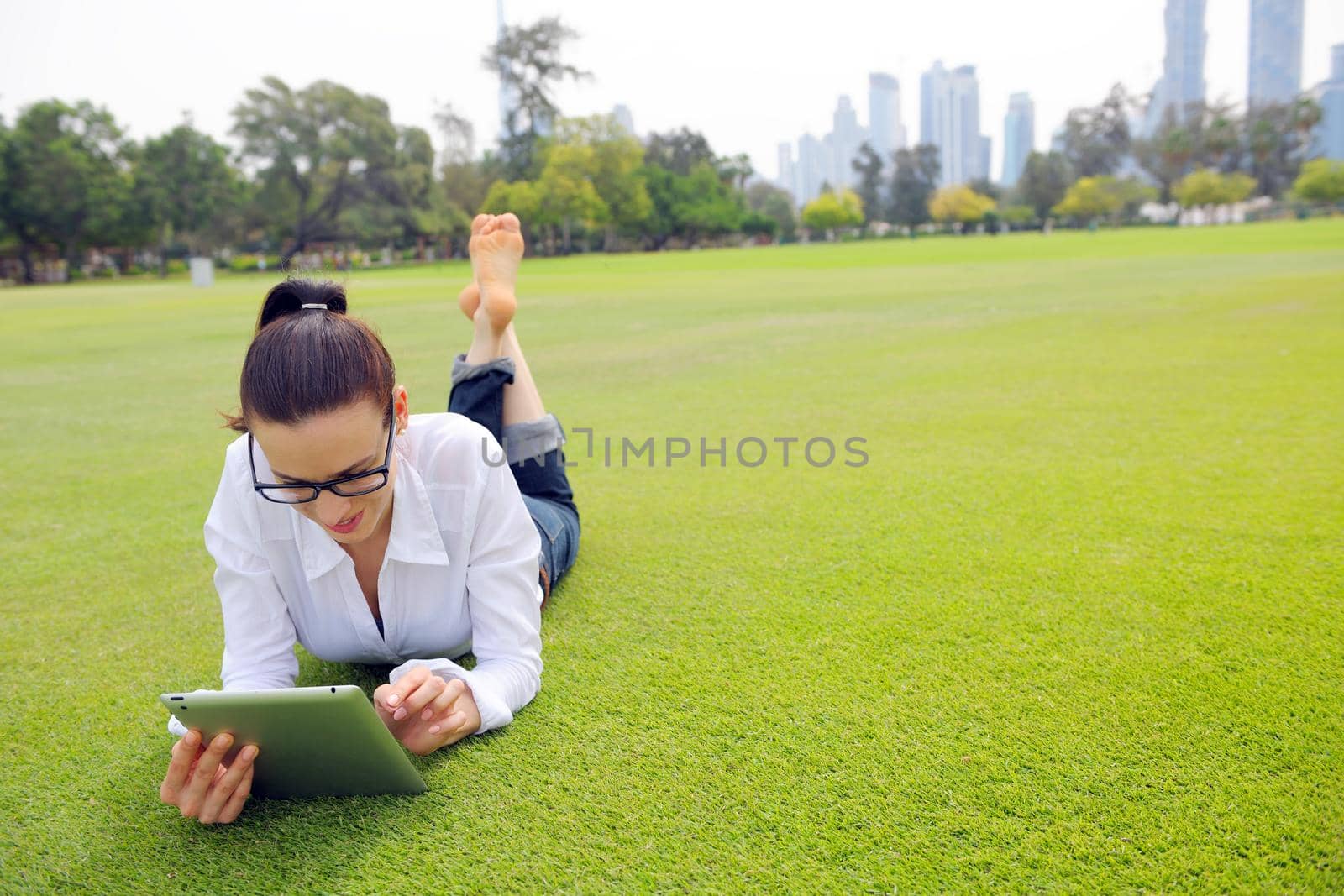 Beautiful young woman with  tablet in park by dotshock