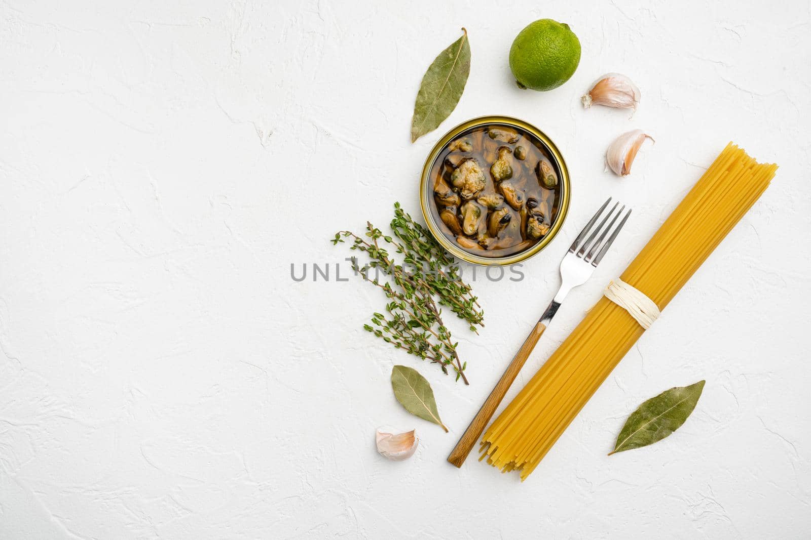 Ingredients for preparation spaghetti with calms or mussels set, on white stone table background, top view flat lay, with copy space for text