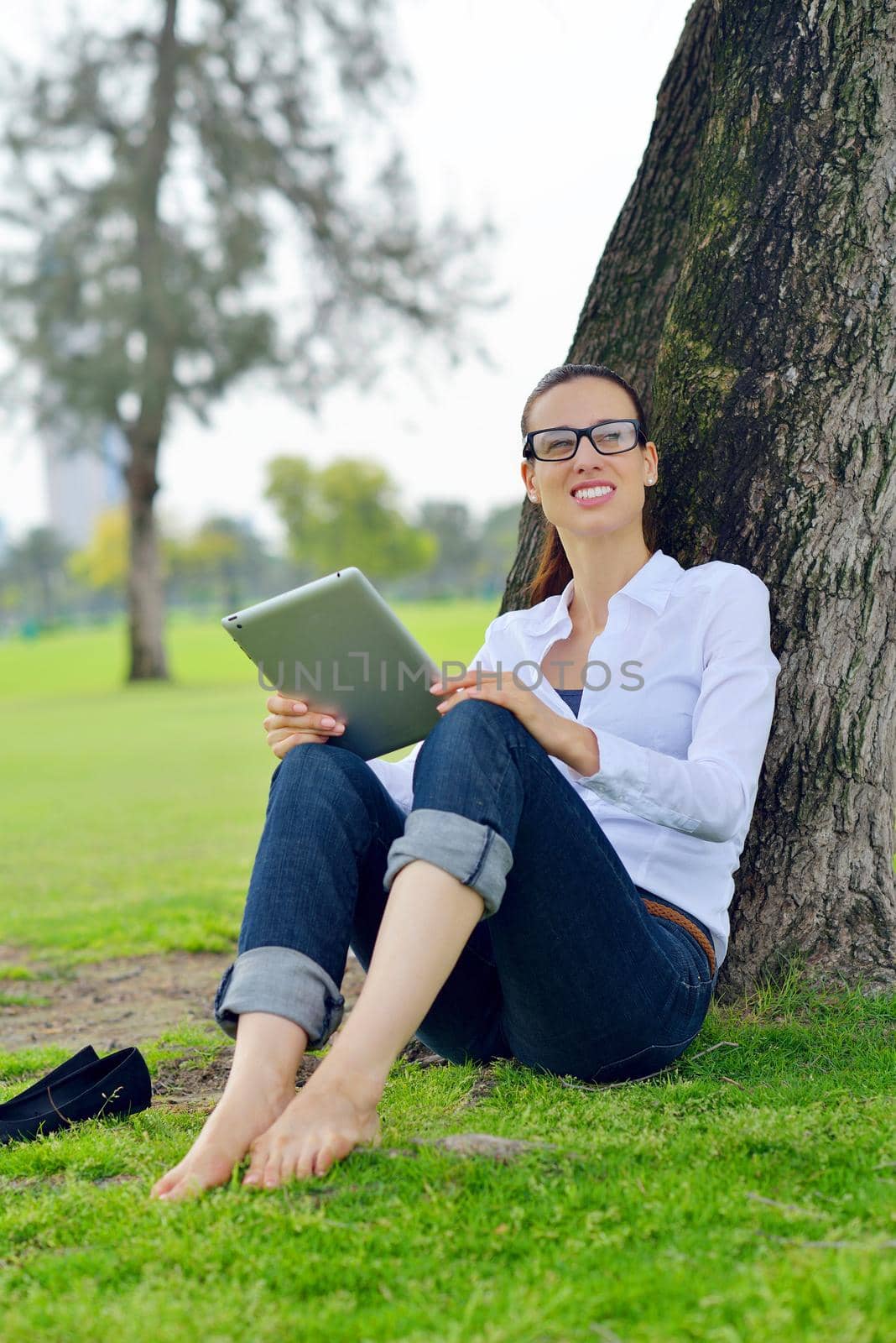 Beautiful young woman with  tablet in park by dotshock