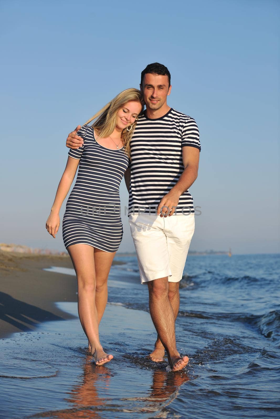 happy young couple have romantic time on beach at sunset