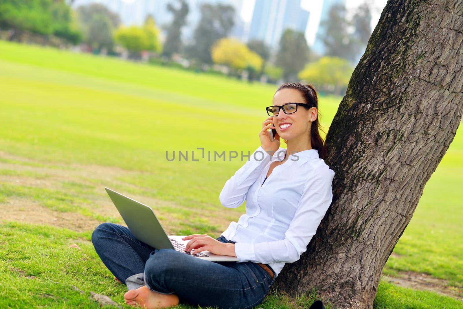 happy young student woman with laptop in city park study