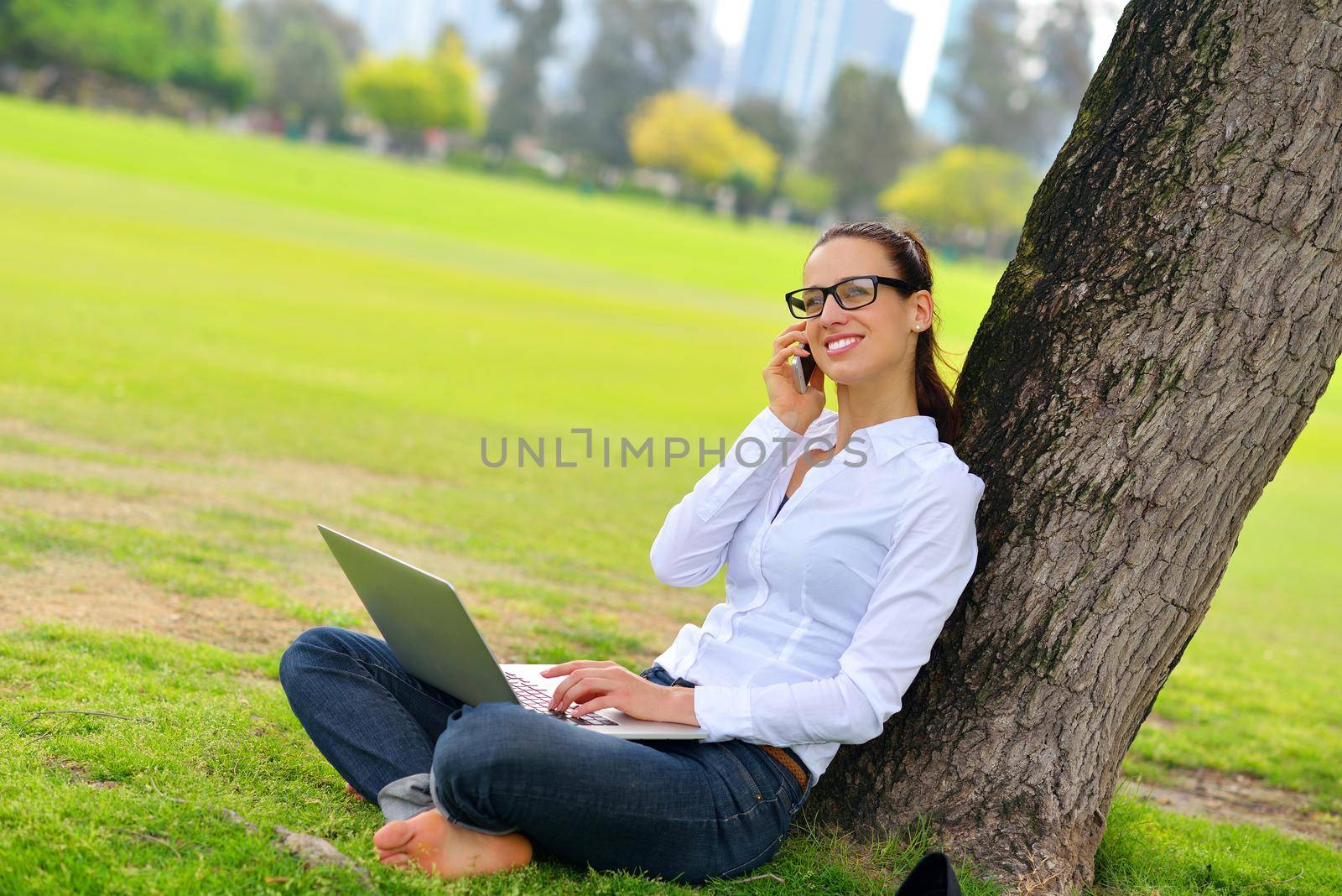 happy young student woman with laptop in city park study