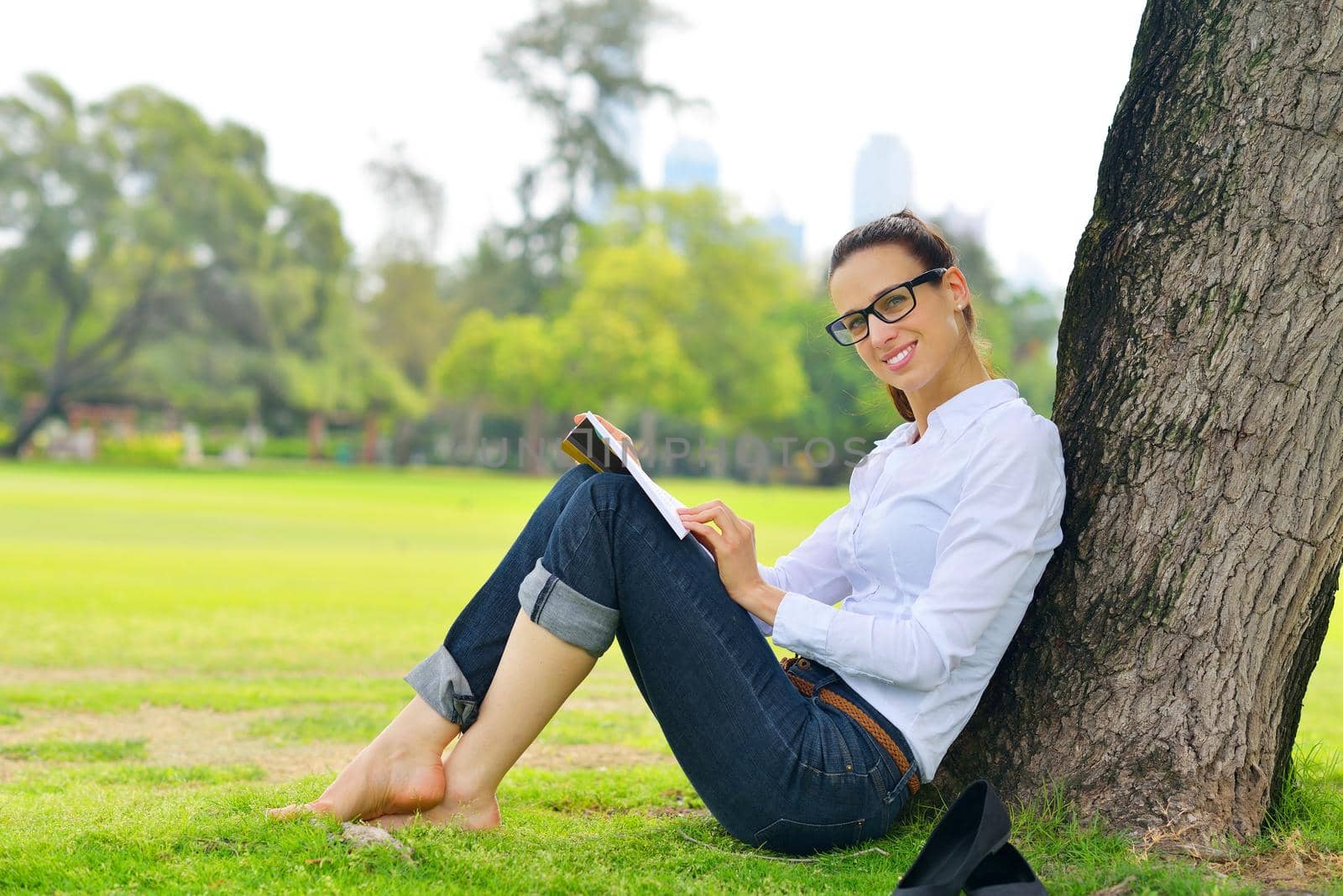 Young student woman reading a book and study in the park