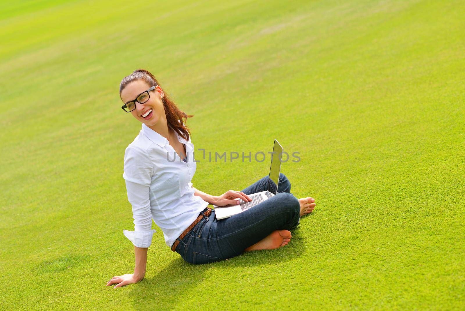 happy young student woman with laptop in city park study