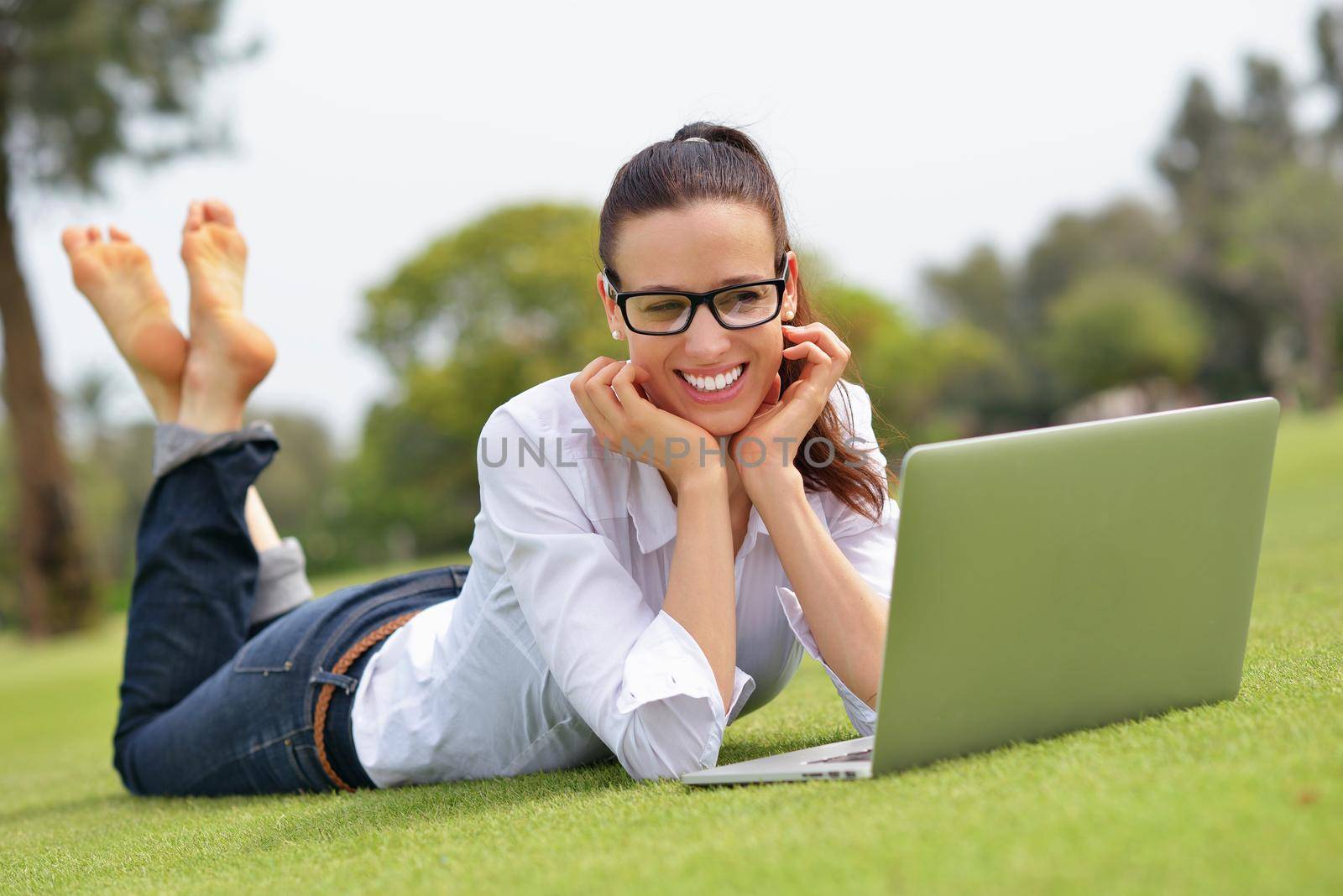 woman with laptop in park by dotshock