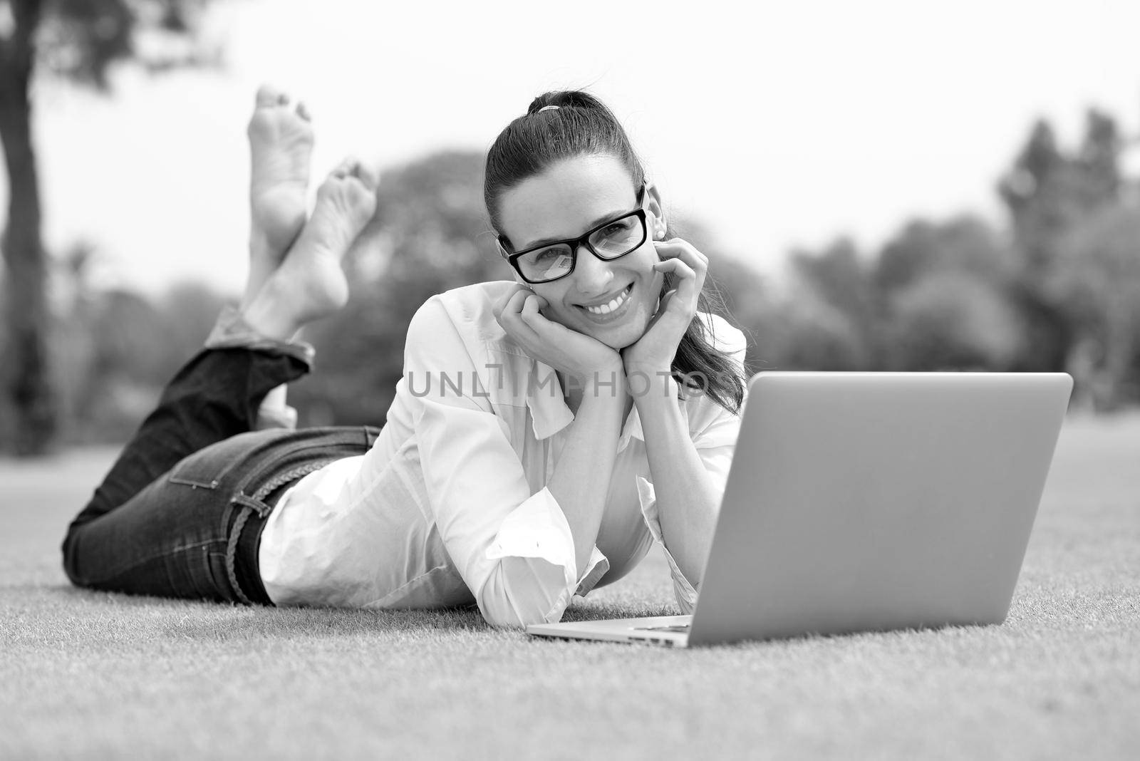 woman with laptop in park by dotshock